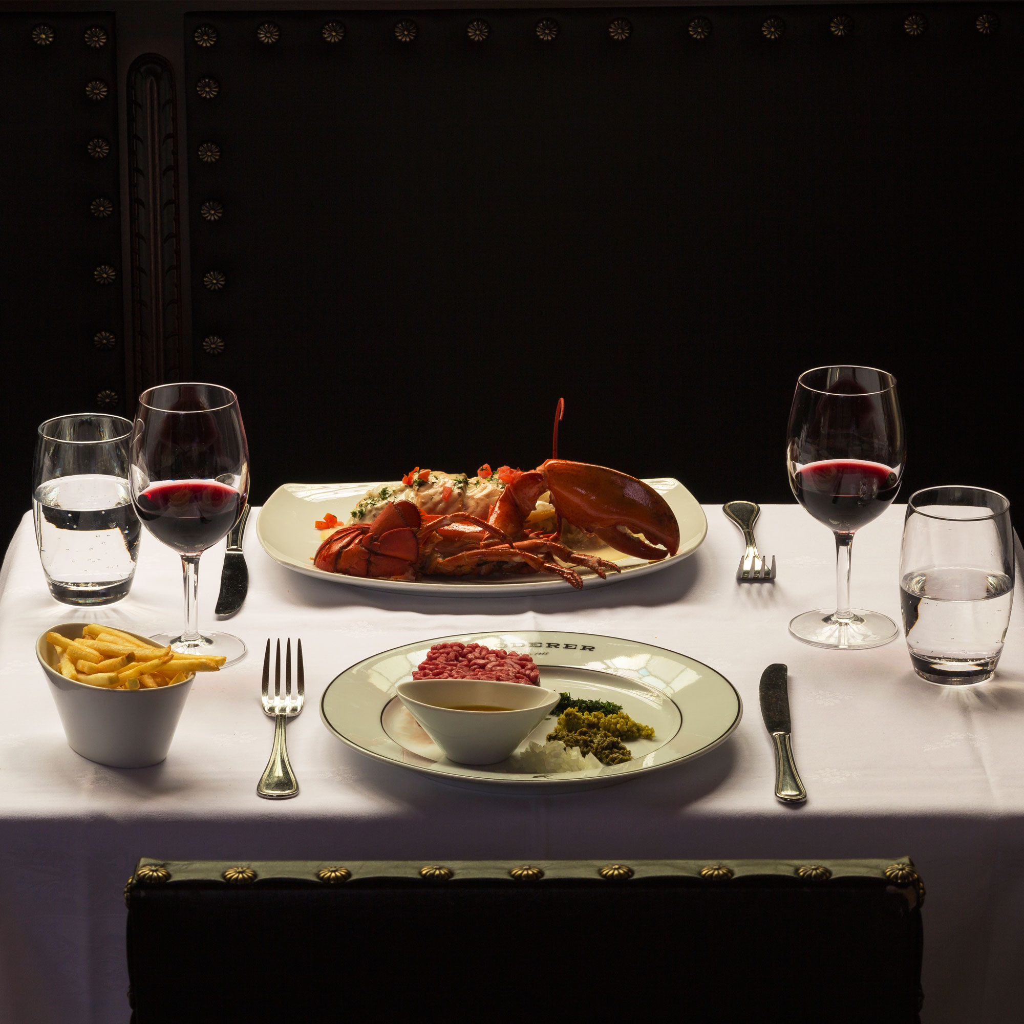 Une assiette de nourriture et des verres de vin sur une table